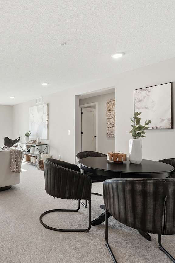 A dining room with a wooden table and grey chairs.