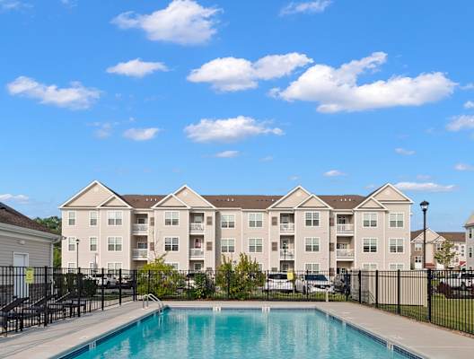 a swimming pool with apartment buildings in the background