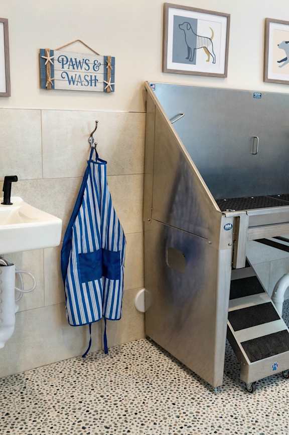 A dog wash station with a sink and a large metal tub.