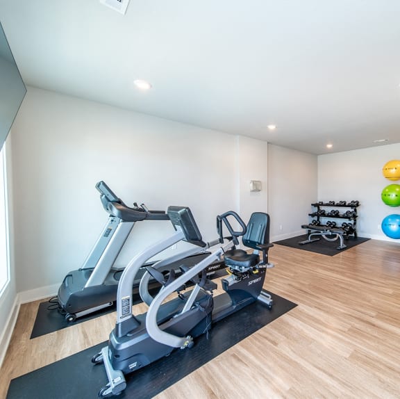 a gym with exercise equipment and a colorful ball on the wall