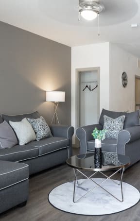 a living room with a brown leather couch and a glass coffee table