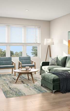 A living room with a green couch and a painting on the wall.