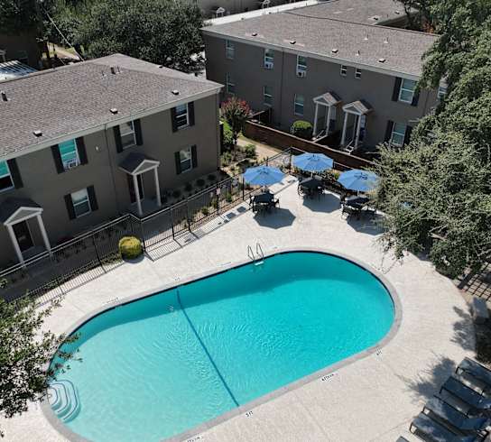 an aerial view of a swimming pool in front of an apartment building