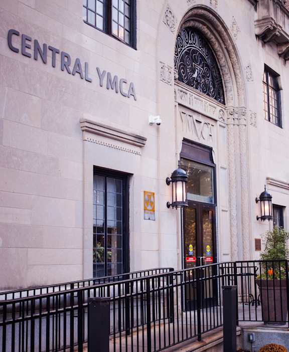 people sit outside of the facade of the central building