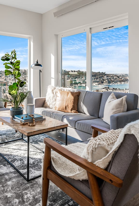 a living room with a leather couch and a kitchen with large windows  at Oslo, Seattle, 98102