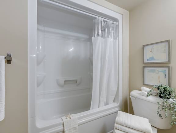 A white bathroom with a glass shower door and a white tub.