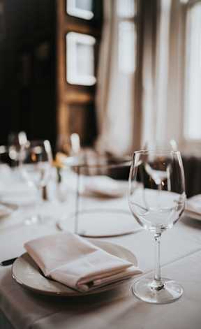 a table with wine glasses and a plate with a napkin
