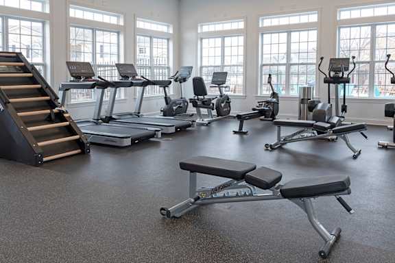 A gym with treadmills, elliptical machines, and a stair climber.