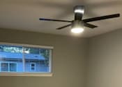 Thumbnail 9 of 19 - A bathroom with a ceiling fan and a window.
