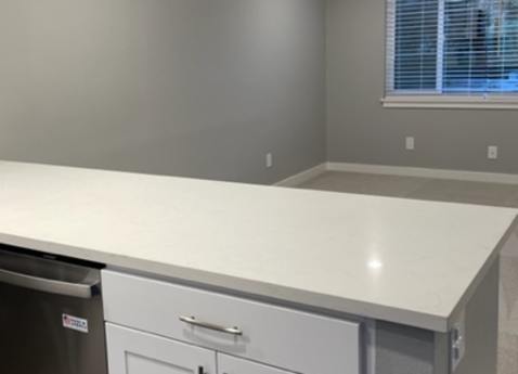 A kitchen with white cabinets and a window.