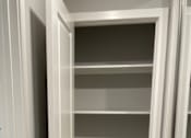Thumbnail 12 of 19 - A white shelf with a silver handle is mounted on a wall.