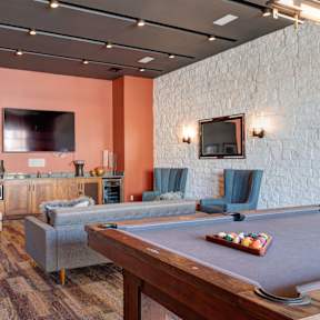A room with a pool table and a tv.