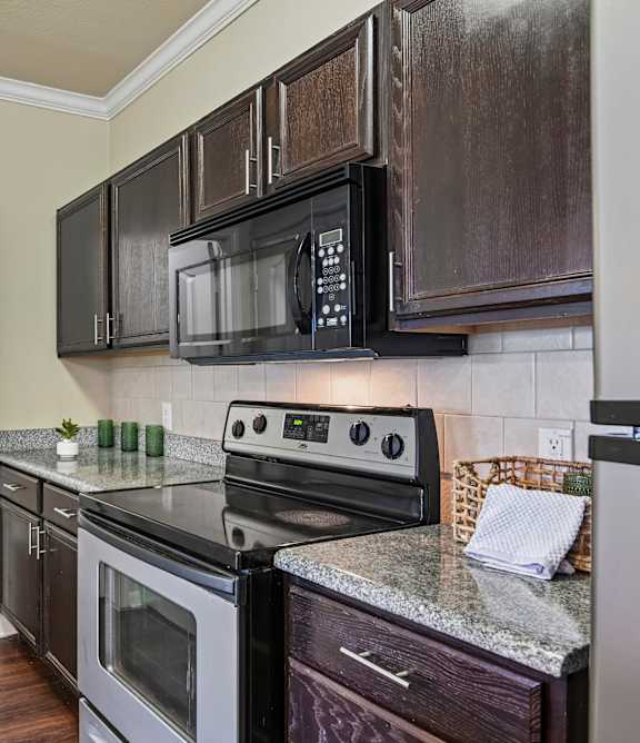 A kitchen with a black microwave above the stove.
