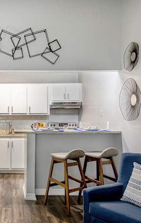 an open kitchen with a granite counter top and stools