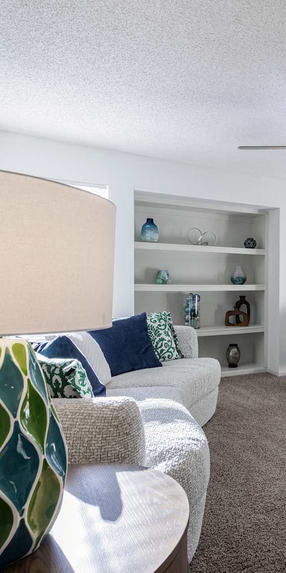 A beautifully arranged living room in a model unit at Skyler Ridge Complex, featuring comfortable seating and warm decor.