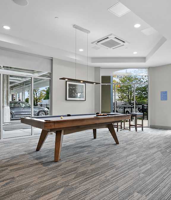 A room with a pool table and a view of the outside.