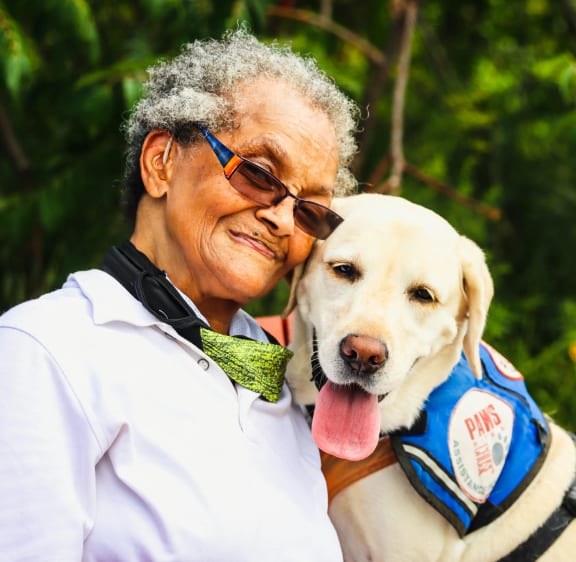 an older woman sitting with a yellow dog