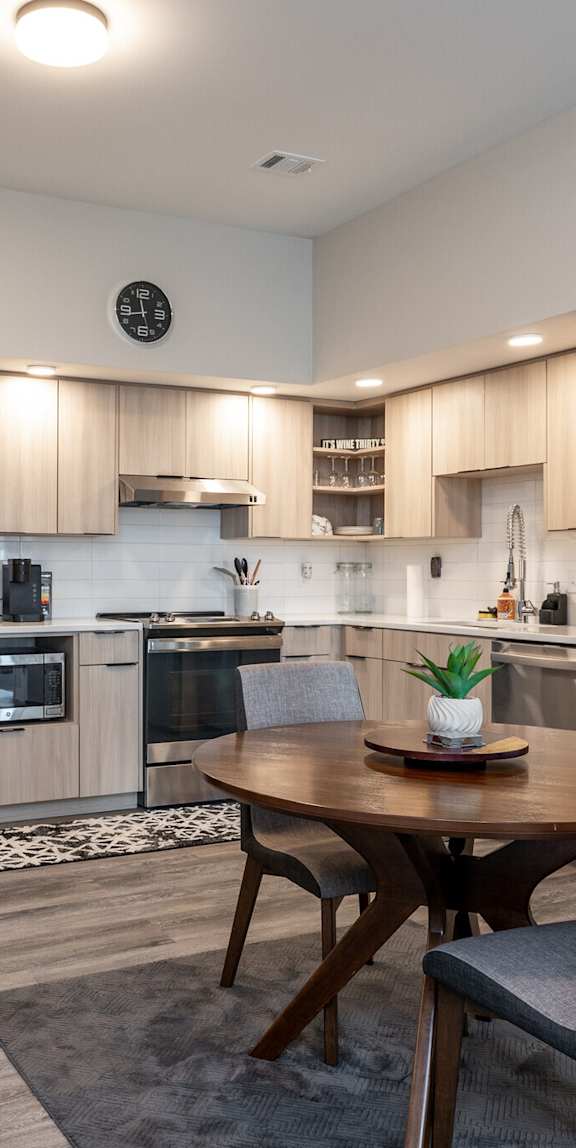 A modern kitchen with a dining table and chairs.
