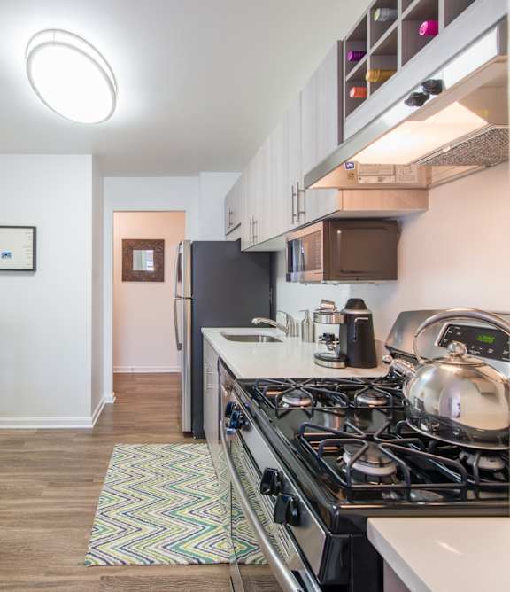A kitchen with a black stove top oven and a black refrigerator.