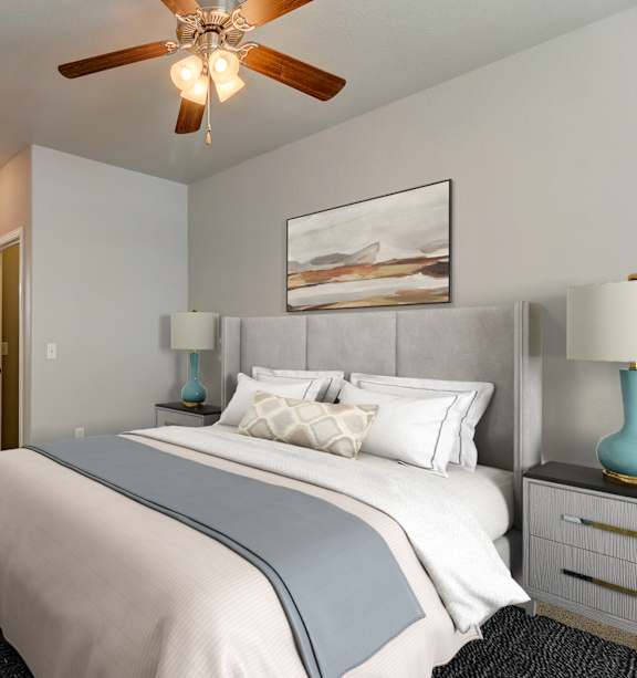 A bedroom with a large bed and a ceiling fan.