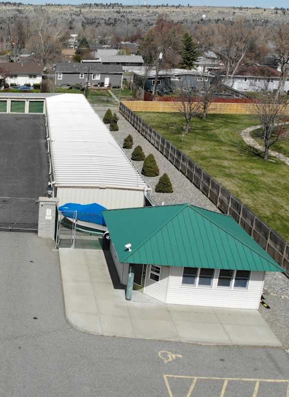 A parking lot with cars and a building with a green roof.
