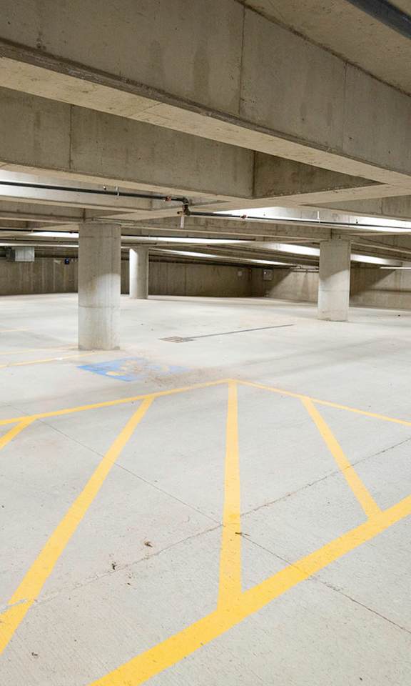A parking garage with yellow lines on the ground.