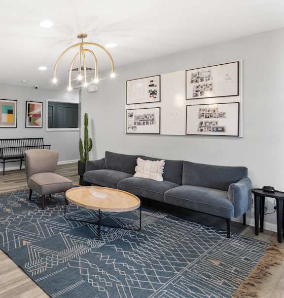 A living room with a grey couch, a coffee table, a side table, and a painting on the wall.at Eagles Edge Apartments, Indianapolis, IN 462542