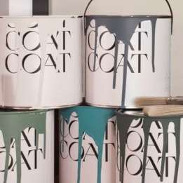 a group of metal canisters sitting on a shelf next to a plant