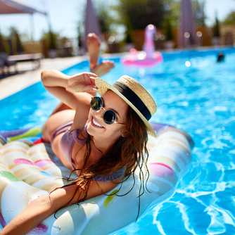 a woman laying on a raft in a swimming pool