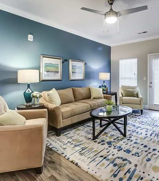 A living room with a beige couch, a coffee table, and a rug.