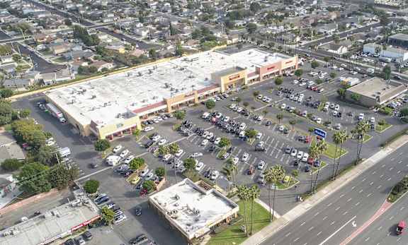 A parking lot is surrounded by buildings and roads.