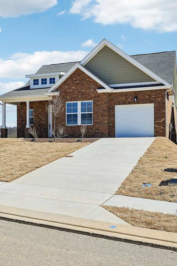 A brick house with a white garage door and a grey roof.