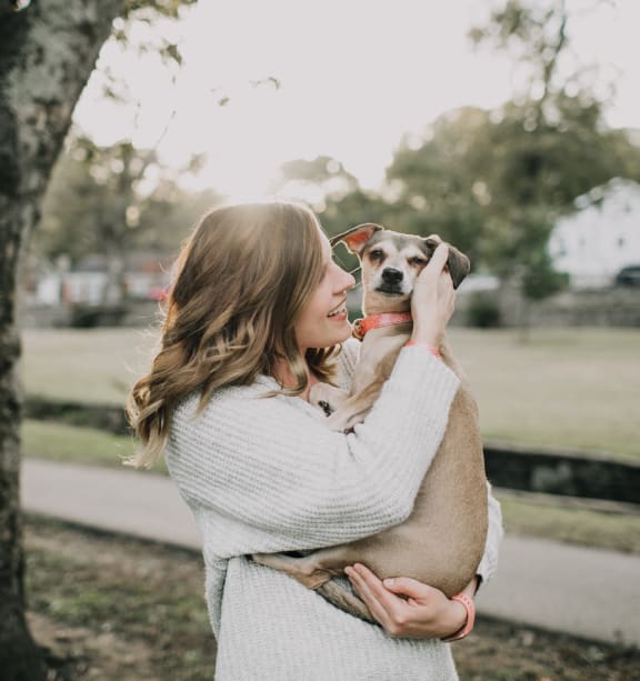 a woman holding a dog in her arms