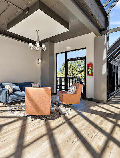 A modern living room with a blue sofa and orange chairs.