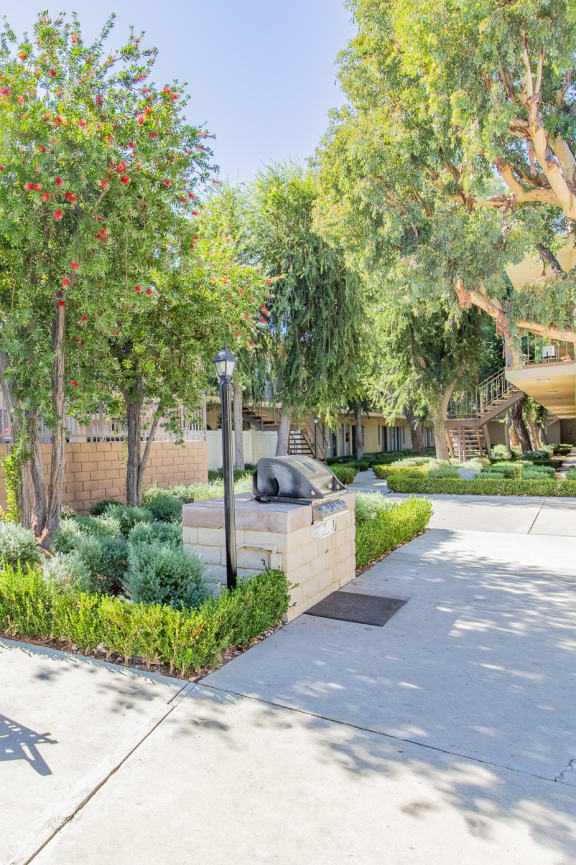 a patio with a table and chairs and a wall and trees