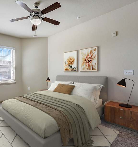 A bedroom with a large bed and a ceiling fan.