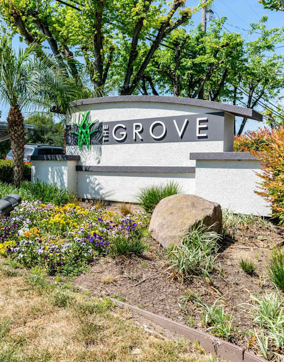 The entrance to The Grove is framed by a flower bed.