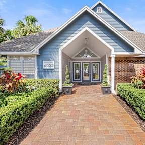 a blue house with a brick pathway leading to the front door