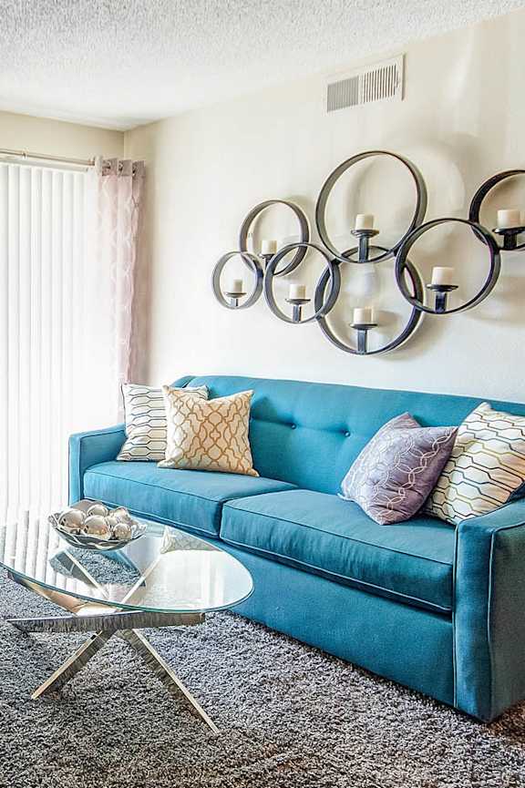 A living room with a blue couch and a fireplace.