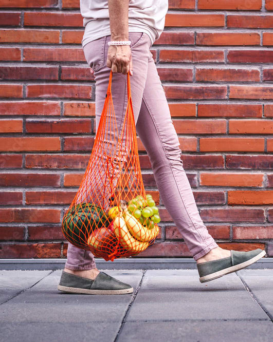 a person walking down the street carrying a bag of fruit  at Prospect East Apartments, Milwaukee, Wisconsin