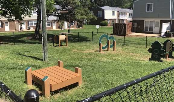 a park bench sitting in the grass next to a fire hydrant at Colony Townhomes, Raleigh, 27609
