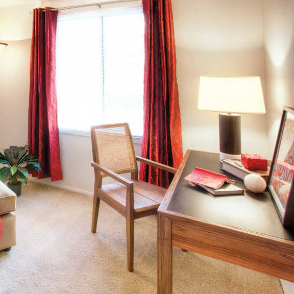 A living room with a beige couch, a chair, a table with a lamp, and a painting on the wall at Hummingbird Pointe & The Gardens, Ohio