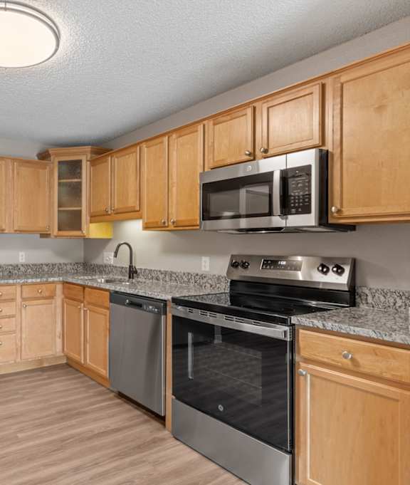 A kitchen with wooden cabinets and stainless steel appliances.