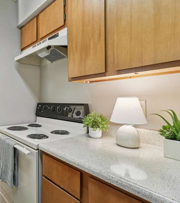 A kitchen with a stove, oven, and a dining table with chairs.