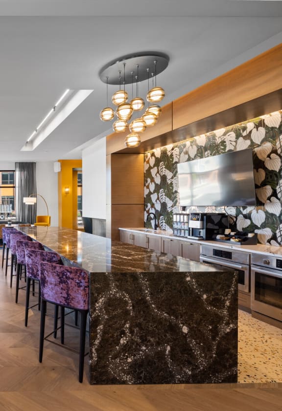 a long bar with purple and yellow chairs and white tables