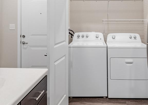 A kitchen with a refrigerator, dishwasher, and oven.