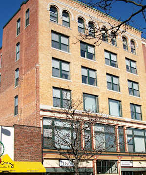 A tall red brick building with many windows.