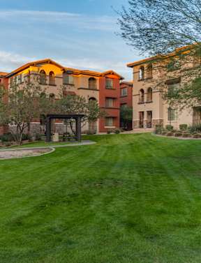 A grassy area in front of apartment buildings.