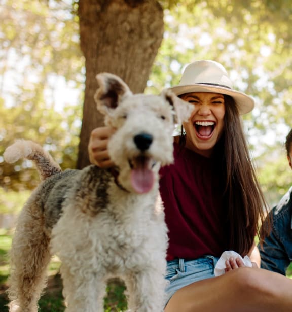 a group of friends sitting in the park with a dog