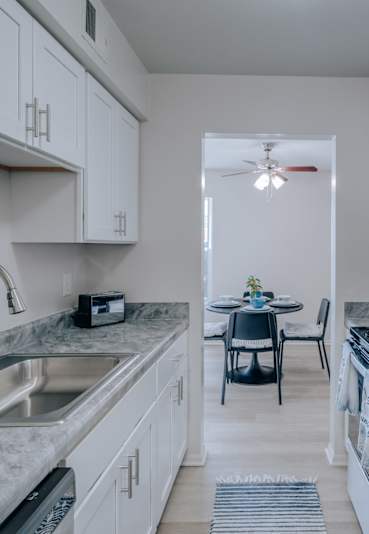 A kitchen with a marble countertop and a stainless steel refrigerator.